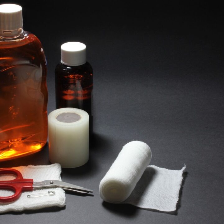 First-aid bandage, gauze, scissors, and antiseptic supplies on a dark surface