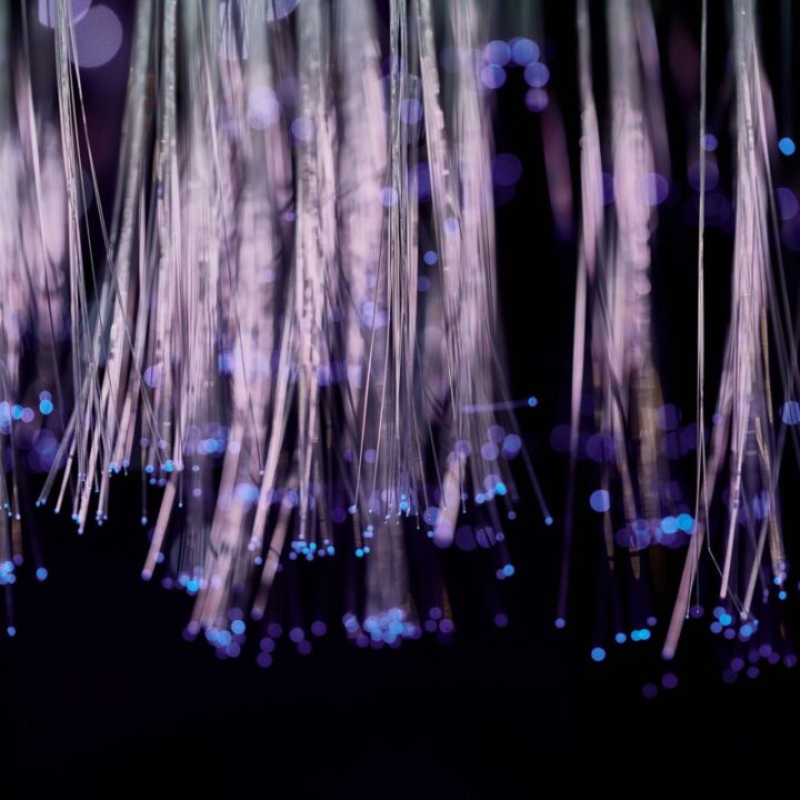 Glowing fiber optic strands representing data moving through a network