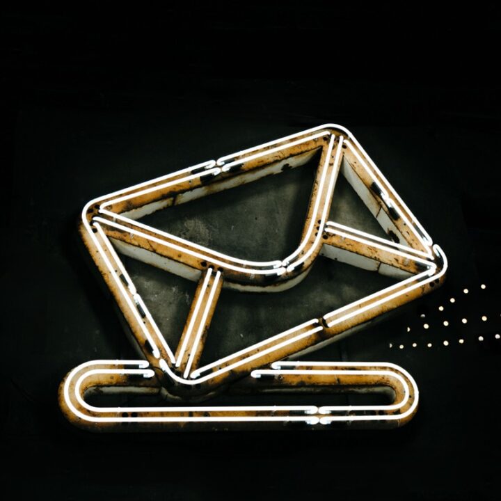 Neon envelope symbol against a dark background