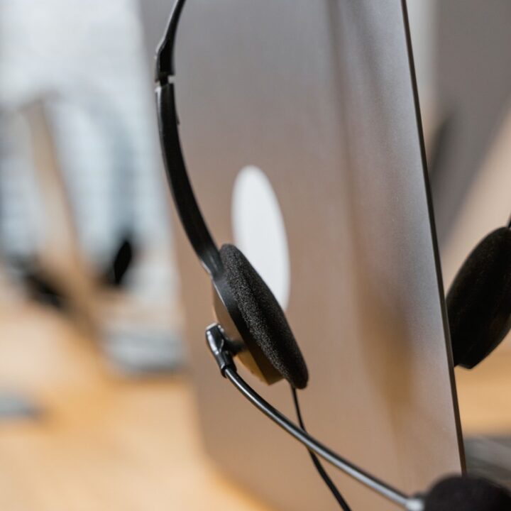 Customer support headset beside a computer monitor