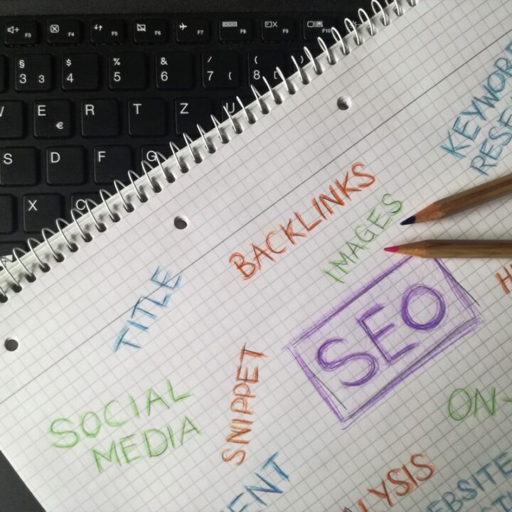 Notebook with SEO keyword research notes beside a keyboard